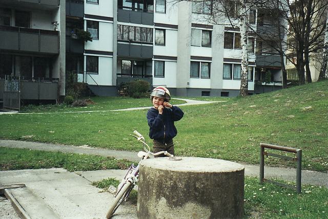 Kind mit Fahrrad auf einem Weg im Innenhof