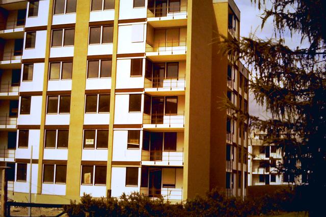 Haus der Siedlung mit gelb-weißer Fassade und Balkonen